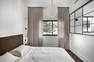 特拉维夫Charming by HolyGuest的一间卧室设有一张大床和两个窗户。