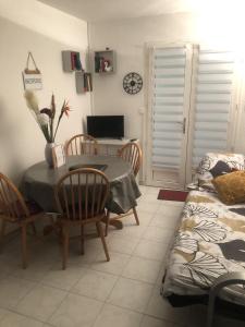 Saint-NicAppartement cosy 100m plage de Pentrez的一间带桌椅和电视的用餐室