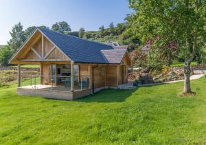 门蒂斯港Gamekeeper's Lodge- a cottage with a spectacular view的庭院中设有太阳能屋顶的小木屋