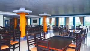 斯里曼加尔乌帕齐拉Tea Heaven Resort的一间带桌椅和窗户的用餐室