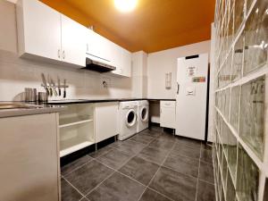 巴塞罗那Arc House Barcelona的厨房配有白色橱柜、洗衣机和烘干机