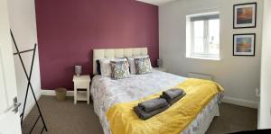 格洛斯特Stunning Large Detached Gloucester, 4 beds, 3 bedroom, 2 bathroom property, Nr Chelt, The Docks and Quays sleeps 6的一间卧室设有一张紫色墙壁的大床