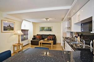 海伯敦桥克罗夫特米尔酒店的厨房以及带沙发和桌子的客厅。