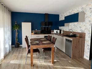卡西斯Entre terre et mer à cassis的厨房配有木桌和蓝色的墙壁
