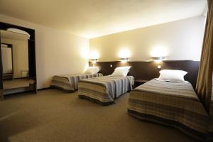 迈松阿尔福贝蒂卡波拉酒店的酒店客房设有两张床和电视。