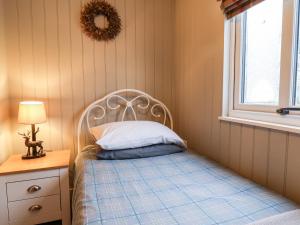 斯卡伯勒Grouse Lodge的一间卧室配有一张带白色床头板的床和窗户