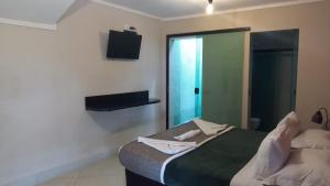 卡拉瓜塔图巴Pousada Sol e Cia Tur的酒店客房,配有床和电视