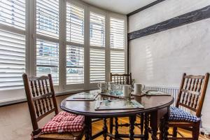 海斯廷斯Modern living, Charming Old Town Cottage的一间带桌椅和窗户的用餐室