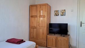 克尔贾利Стаи за гости "Пламена"的一间卧室配有电视和木制衣柜