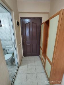 安塔利亚Caner Mountain Hotel的浴室设有棕色的门和卫生间。