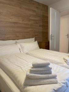 摩德纳迪-坎皮格里奥Appartamento del rosengarten的三条毛巾被堆在一张白色的床上