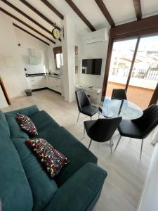 阿达莱斯ATICO BUENAVISTA的客厅配有绿色沙发和玻璃桌
