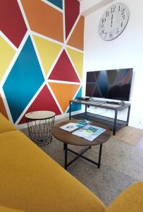 布雷斯特Quatre Moulins - 3 chambres - WIFI - Refait à neuf的色彩缤纷的客房,墙上设有桌子和时钟