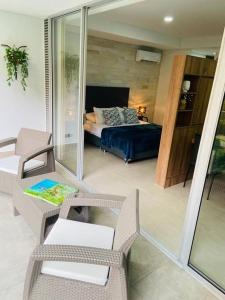 卡利Apartamento en Granada con piscina, turco, estacionamiento的一间带床的客厅和一间带椅子的房间