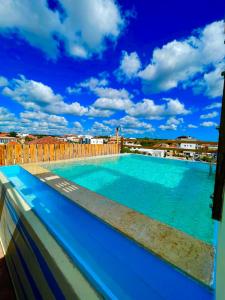 巴亚希贝宜古纳别墅的一座大型蓝色游泳池,位于一座建筑的顶部
