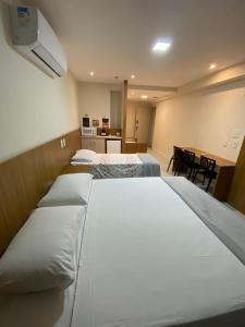 坎普斯戈伊塔卡济斯Quarto para 4 pessoas的酒店客房设有三张床和一张书桌