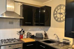 巴克斯顿Pavilion View的厨房配有水槽和墙上的时钟