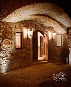 SanteaguedaVilla Toscana ValQuirico Lofts & Suites Hotel Boutique的石头建筑的入口,有门
