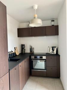 开姆尼茨Modernes Apartment in zentraler Lage的厨房配有木制橱柜和黑色台面