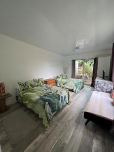 帕皮提TEA TAHITI Holidays的一间卧室配有两张床和一张桌子