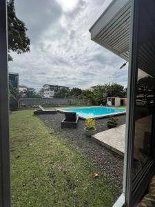 帕皮提TEA TAHITI Holidays的一个带游泳池和房子的后院
