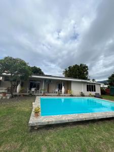 帕皮提TEA TAHITI Holidays的庭院中带游泳池的房子