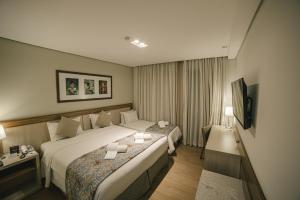 伊瓜苏Interludium Iguassu Hotel by Atlantica的酒店客房设有两张床和电视。