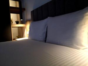 科莫蒂尼Insomnia studio Komotini的一间卧室配有带白色床单和枕头的床。