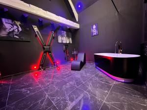 Douchy-les-MinesLoveroom de luxe - Thème 50 nuances de grey maison privative spa insolite的带浴缸的浴室和红色的灯光,位于地板上