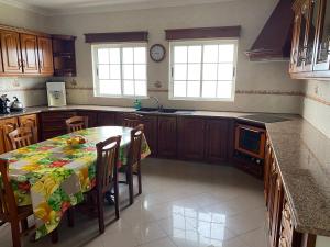 蓬塔德尔加达Green Tropical House的厨房配有桌椅和2扇窗户。