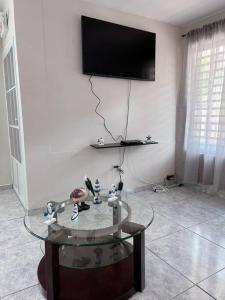 阿瓜迪亚Orsini Beach Apartment的客厅配有玻璃桌和平面电视。