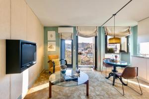 波尔图波尔特拉之家城市公寓酒店的客厅配有电视和桌椅