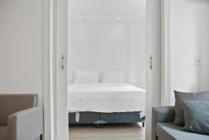 圣保罗Hotel Luxuoso na Paulista的卧室配有白色的床和蓝色的沙发