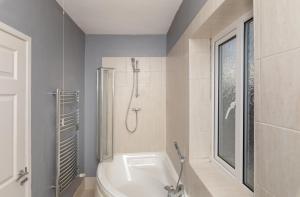 蒂斯河畔斯托克顿Tibbersley House Billingham With Parking的浴室配有白色浴缸和淋浴。