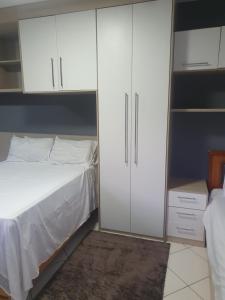 维拉维尔哈SUÍTE PRAIA DE ITAPARICA的一间卧室配有一张床和白色橱柜