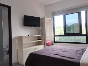 圣萨尔瓦多德朱Departamento XIBI的一间卧室设有一张床、一台电视和一个窗口。