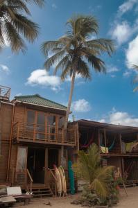 GuachacaMendihuaca Surf Camp的海滩上一棵棕榈树的房子