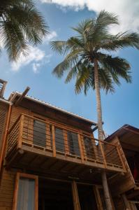 GuachacaMendihuaca Surf Camp的前面有棕榈树的房子