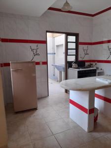 塔里哈Cómo en hogar的厨房配有桌子、冰箱和台面