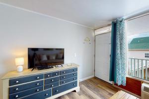 大洋城Ocean Waye 226的一间卧室配有蓝色梳妆台,配有电视