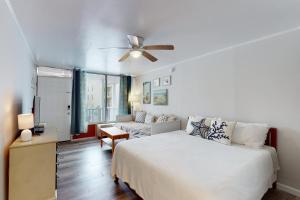 大洋城Ocean Waye 226的一间卧室配有一张床和吊扇