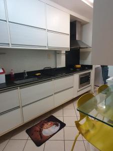 卡鲁阿鲁Apartamento Caruaru的厨房配有白色橱柜、水槽和桌子