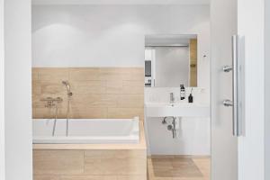 腓特烈港赫尔曼班戈贝斯特韦斯特酒店的白色的浴室设有浴缸和水槽。