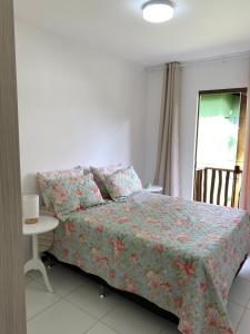 卡马萨里Village Itacimirim的一间卧室配有一张床、一张桌子和一个窗户。