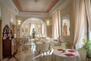 罗马Hotel Canada, BW Premier Collection的一间设有白色桌子和白色椅子的餐厅