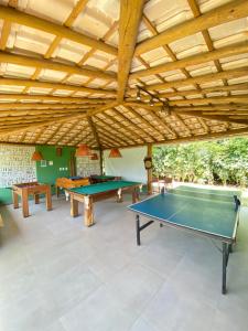 卡马萨里Village Itacimirim的一间设有两张乒乓球桌和木制天花板的房间