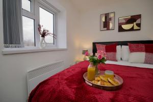 考文垂Swan Studio Five - Coventry的一间卧室配有一张红色的床,上面放着一个食物托盘