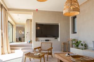 凯法利尼亚岛Apeiron Villas的客厅配有电视和桌子
