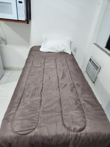 里约达欧特拉斯POUSADA FLOR DO CARIBE的棕色毯子的房间里一张床位