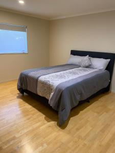 奥克兰3 Bedroom Holiday Apartment Peninsula Park的一间带床的卧室,位于带窗户的房间内